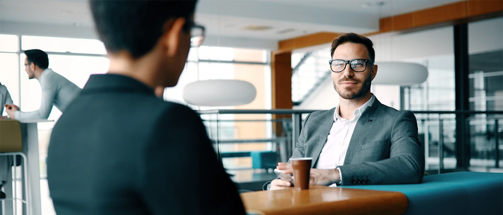 Dois homens de terno sentados em uma mesa